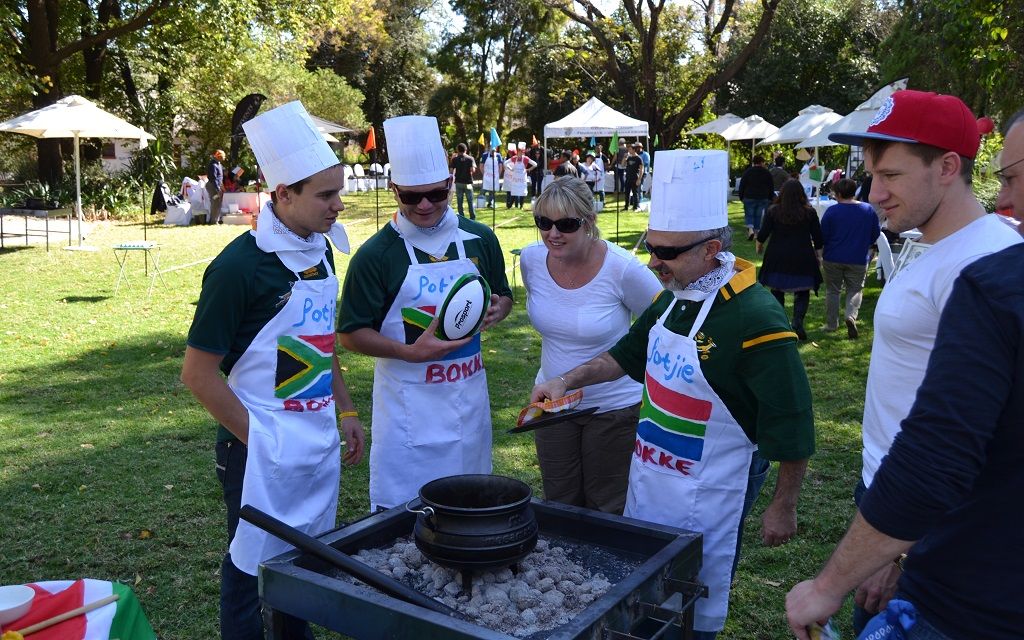 Teams in South African aprons competing in an outdoor braai and potjie cook-off